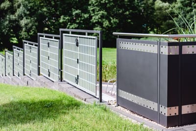 Sichtschutzzaun aus Metall mit eingesetzten Gitterfeldern.